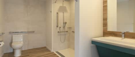 A modern bathroom with a shower, toilet, and sink.