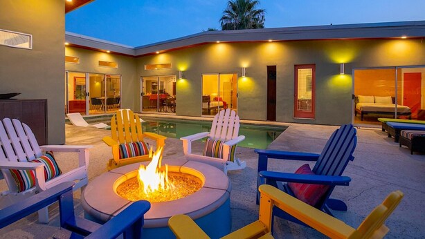 Eine moderne Außenpatio mit Feuerstelle, Lounge-Sesseln und Poolbereich.