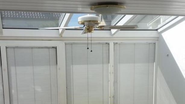 A sunlit room with a sofa, a glass coffee table, and a ceiling fan. - Fewo Mayer am Bodensee (Friedrichshafen)
