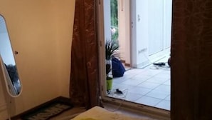 A bedroom with a bed, a mirror, and a sliding glass door leading to a balcony. - Fewo Mayer am Bodensee (Friedrichshafen)