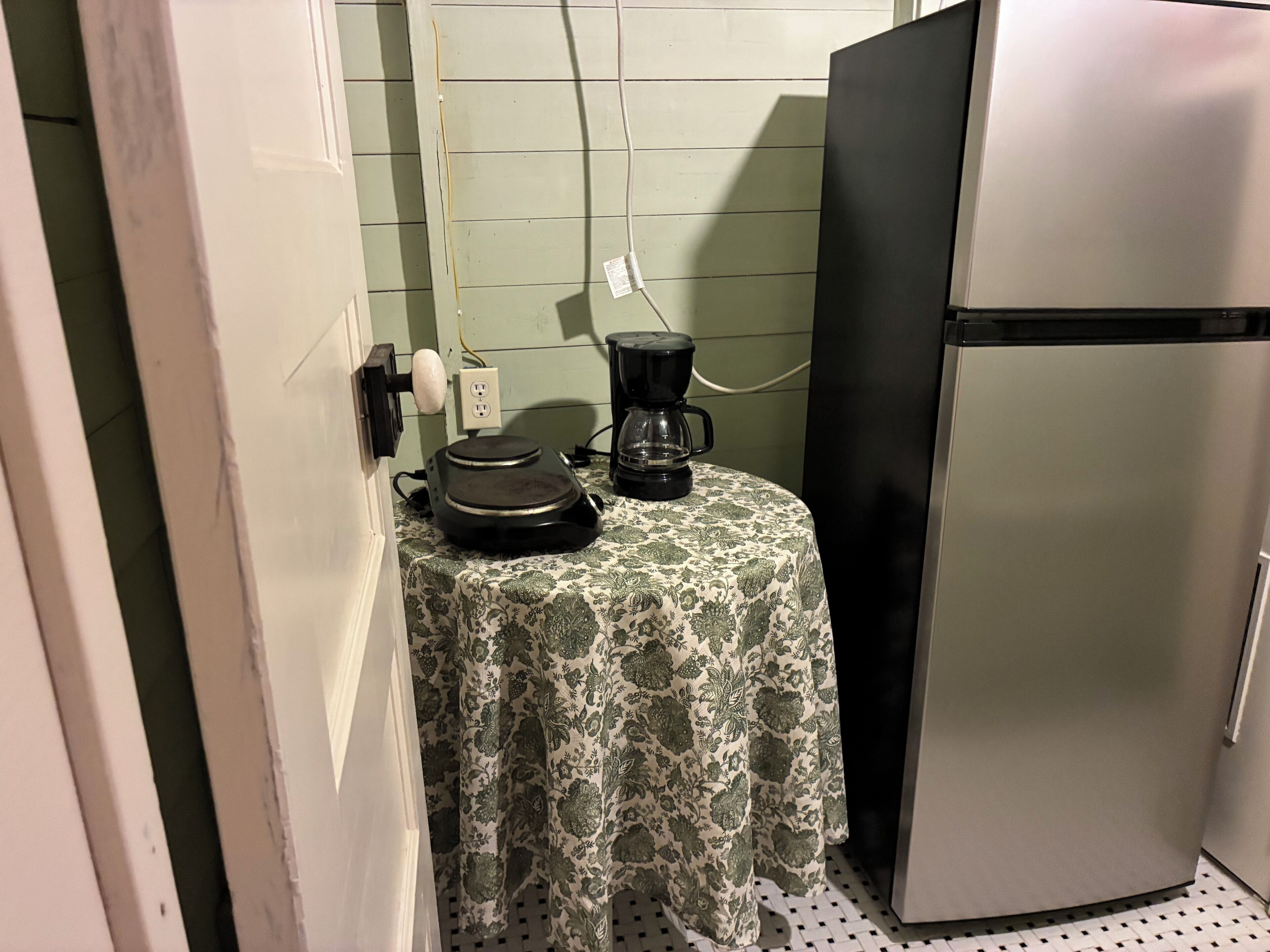 Un angolo cottura attrezzato con macchina del caffè, tostapane e frigorifero.