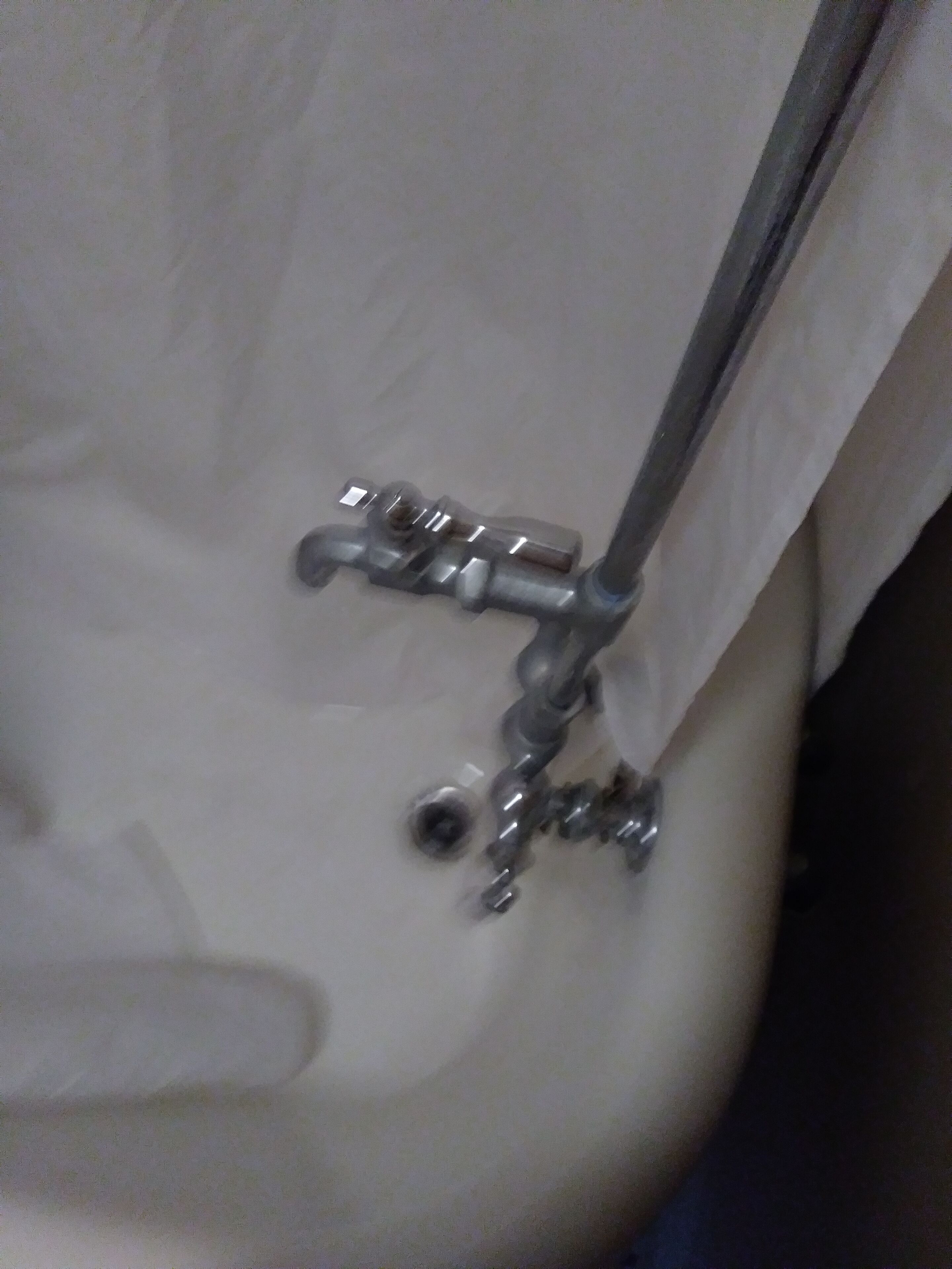 A close-up of a bathroom fixture, including a faucet and a showerhead.