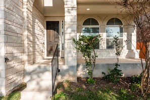 Symmetrical facade with a covered porch and well-maintained garden.