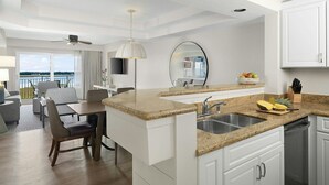 A modern kitchen with granite countertops, a built-in sink, and a dining area with a view.