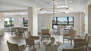 A spacious indoor area with a dining table, chairs, and a large window with a view.