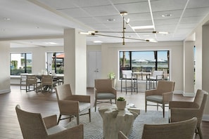 A spacious indoor area with a dining table, chairs, and a large window with a view.