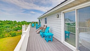 A covered deck with outdoor furniture and a large sliding glass door. - Soundside Home w/ Private Pool, Hot Tub, Game Room, Cabana, Community Boat Ramp (Salvo)