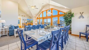 A spacious dining area with a high ceiling, large windows, and a view of the outside. - Oceanview w/ Private Pool, Hot Tub, Game Room, and Wet Bar. Surf's Up Rodanthe! (Rodanthe)