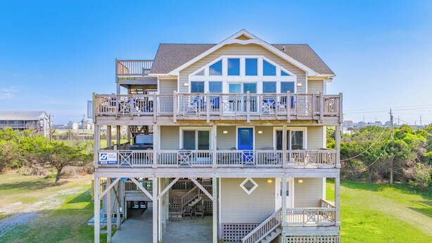 A two-story beachfront house with a balcony, a covered entryway, and a visible garage. - Oceanview w/ Private Pool, Hot Tub, Game Room, and Wet Bar. Surf's Up Rodanthe! (Rodanthe)