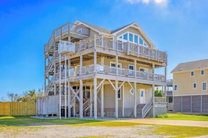 A two-story building with a balcony and a covered area, possibly a beach house.