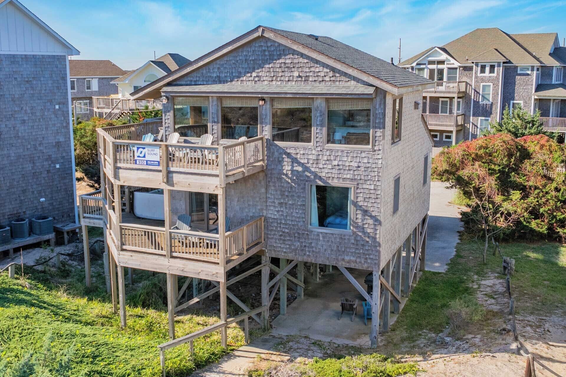 A two-story wooden house with a balcony and a sign indicating a surf sound level of 930.