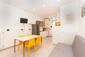 A modern kitchen with white cabinets, a stainless steel refrigerator, and a built-in oven.