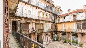 A courtyard with multi-story buildings, balconies, and a central open space. - GuestHost - Studio apartment 5 minutes from the Mole and Royal Gardens! (Torino)