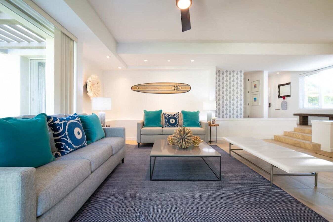 A modern living room with a sofa, a coffee table, and a staircase.