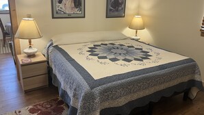 A bedroom with a bed, two wall-mounted lamps, and two framed pictures. - Adults 25 plus Only, Creekside Vacation Rental 1, Downtown Historic CITY APPROVE (Buffalo)
