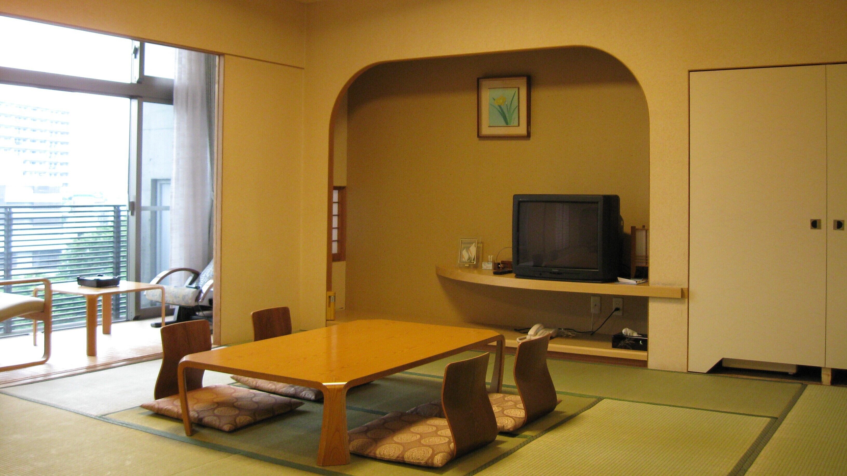 A room with a wooden table, chairs, a television, and a picture on the wall.