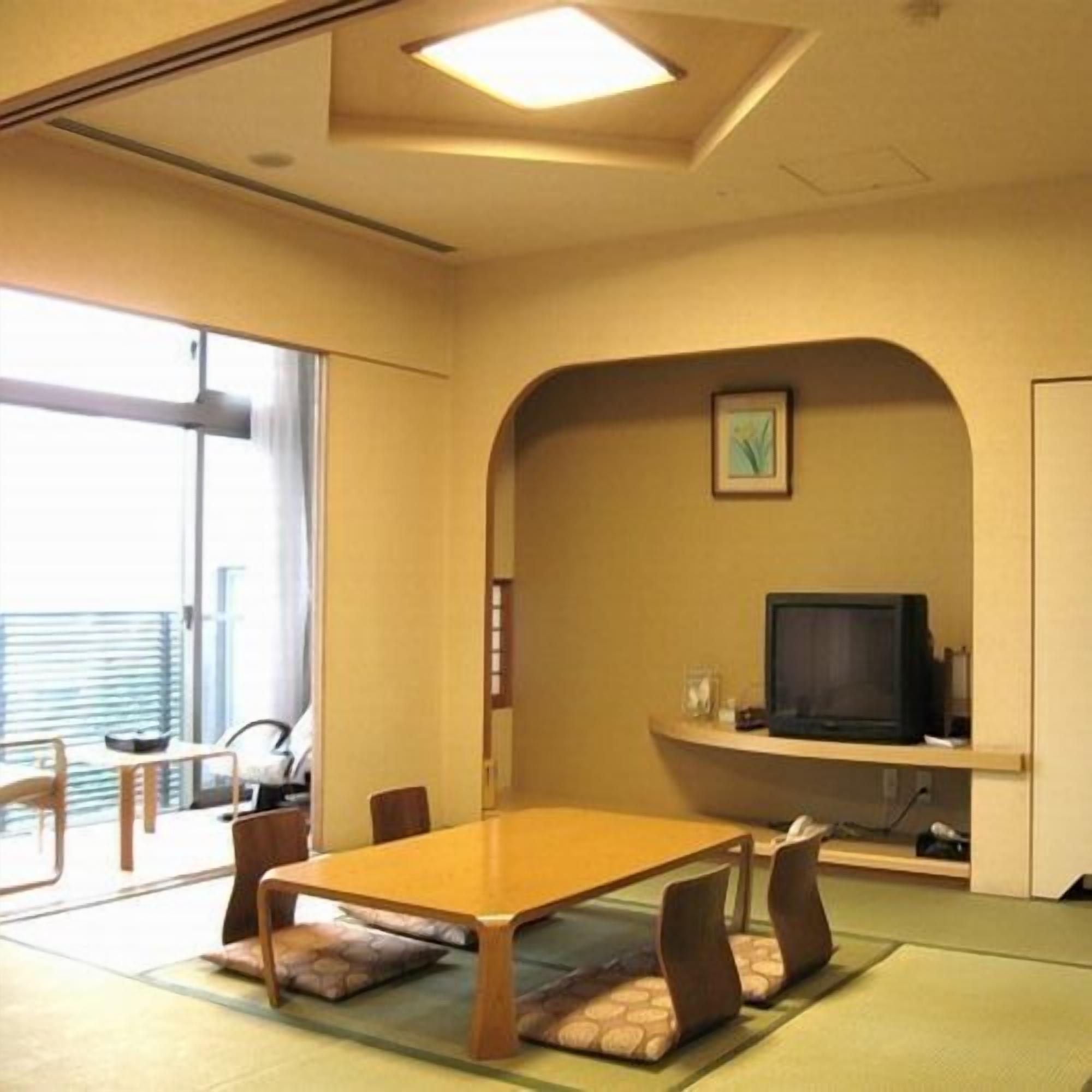 A conference room with a table, chairs, a television, and a picture on the wall.