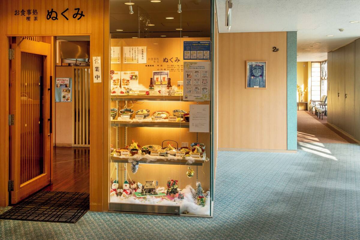A traditional Japanese restaurant with a wooden interior, a display of dishes, and a Christmas decoration.