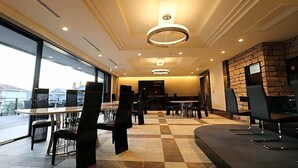 Un lobby de hotel moderno con piso a cuadros, pared de acento de piedra y un ventanal con vistas.