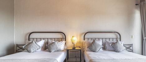 Une chambre avec deux lits, une table de chevet avec une lampe et un plafond en bois.