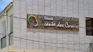 Een gebouw met een bord waarop staat: Pousada Cantinho dos Corais.