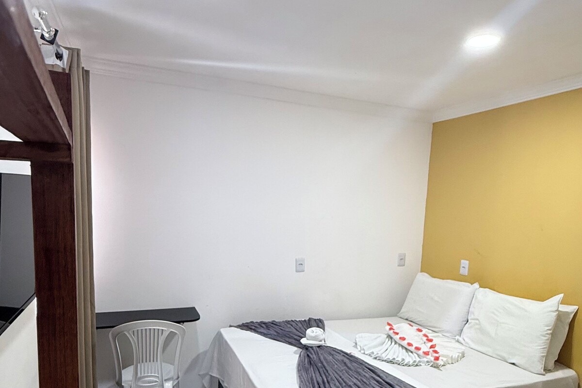 Ein Schlafzimmer mit einem Bett, einem Nachttisch und einem Sessel.
