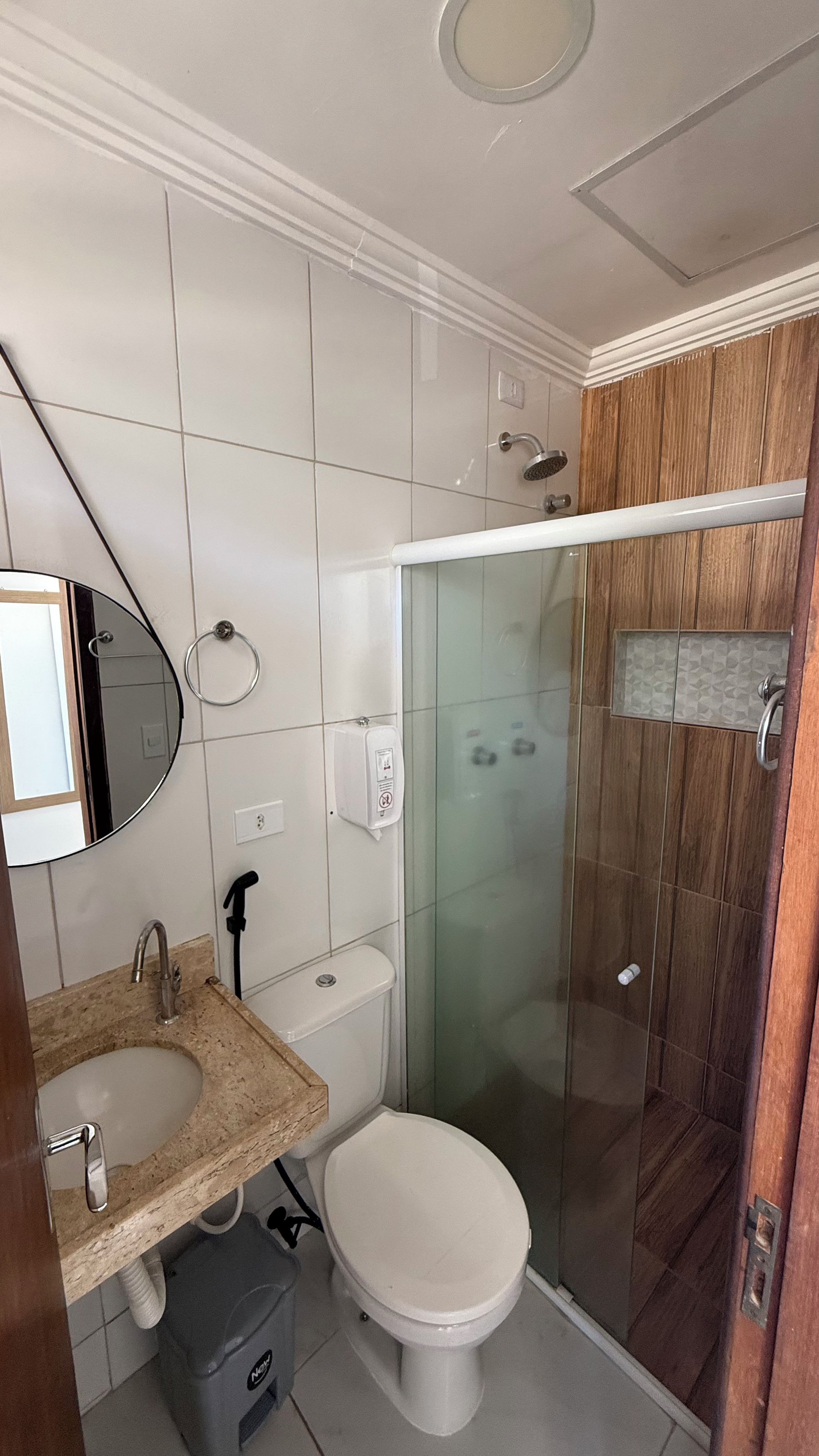 Une salle de bain avec des toilettes, un lavabo et une douche.