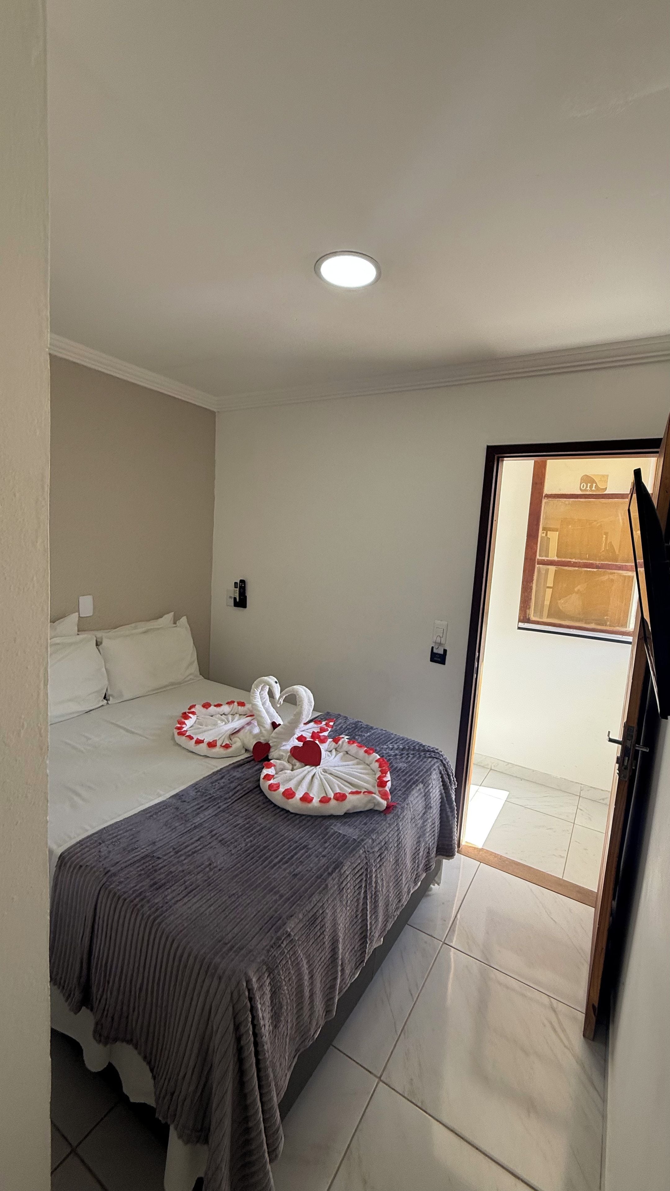 Habitación de hotel con cama, ventana y puerta.