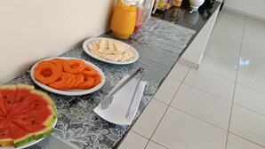 Een ontbijtbuffet met verschillende soorten fruit en drankjes.