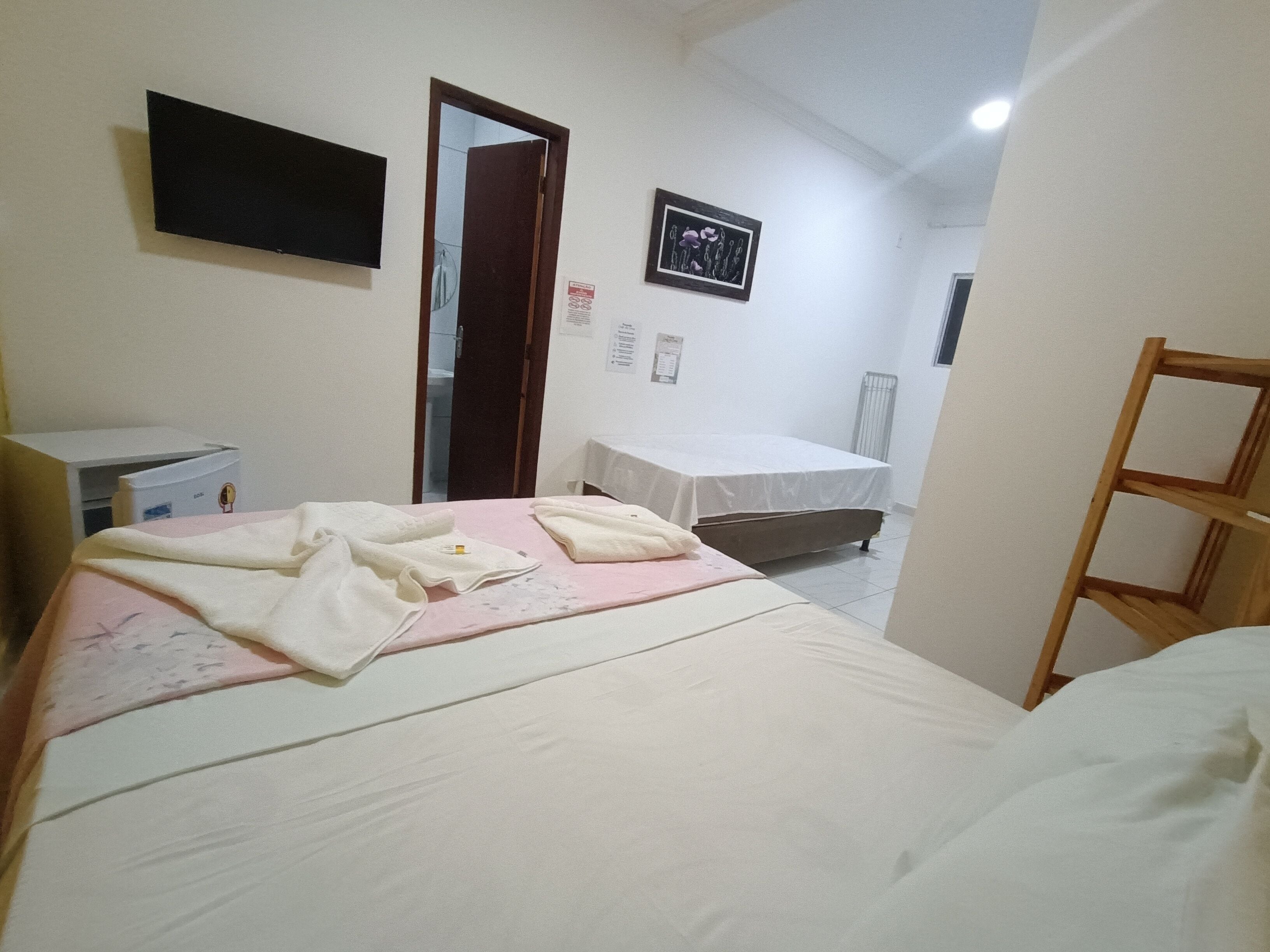 Un dormitorio con una cama, un escritorio, una silla, un radiador y una puerta.