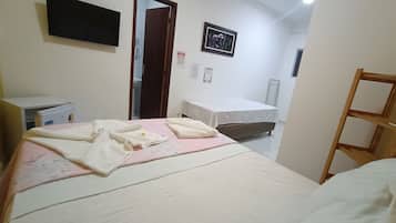 Un dormitorio con una cama, un escritorio, una silla, un radiador y una puerta.