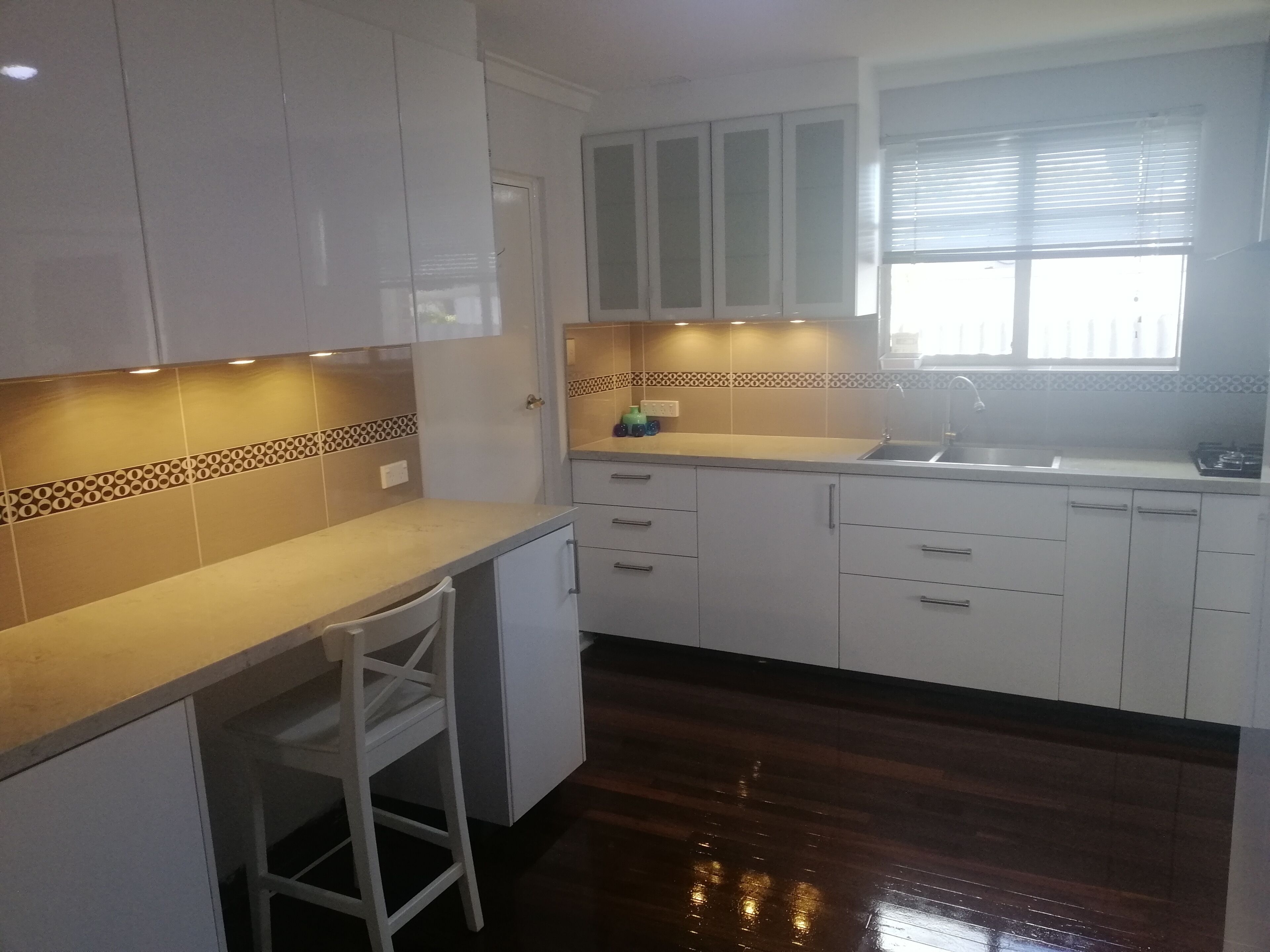 A kitchen with white cabinets, a countertop, and a window.