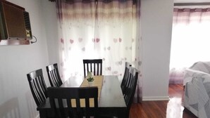 A dining area with a wooden table and six chairs, a potted plant, and a radiator on the wall. - Cosy and immaculate 3-bedroom home (Lynwood)