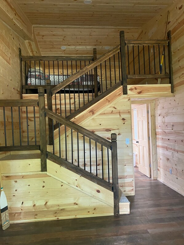 Un interior de madera con una escalera que sube a un nivel superior.