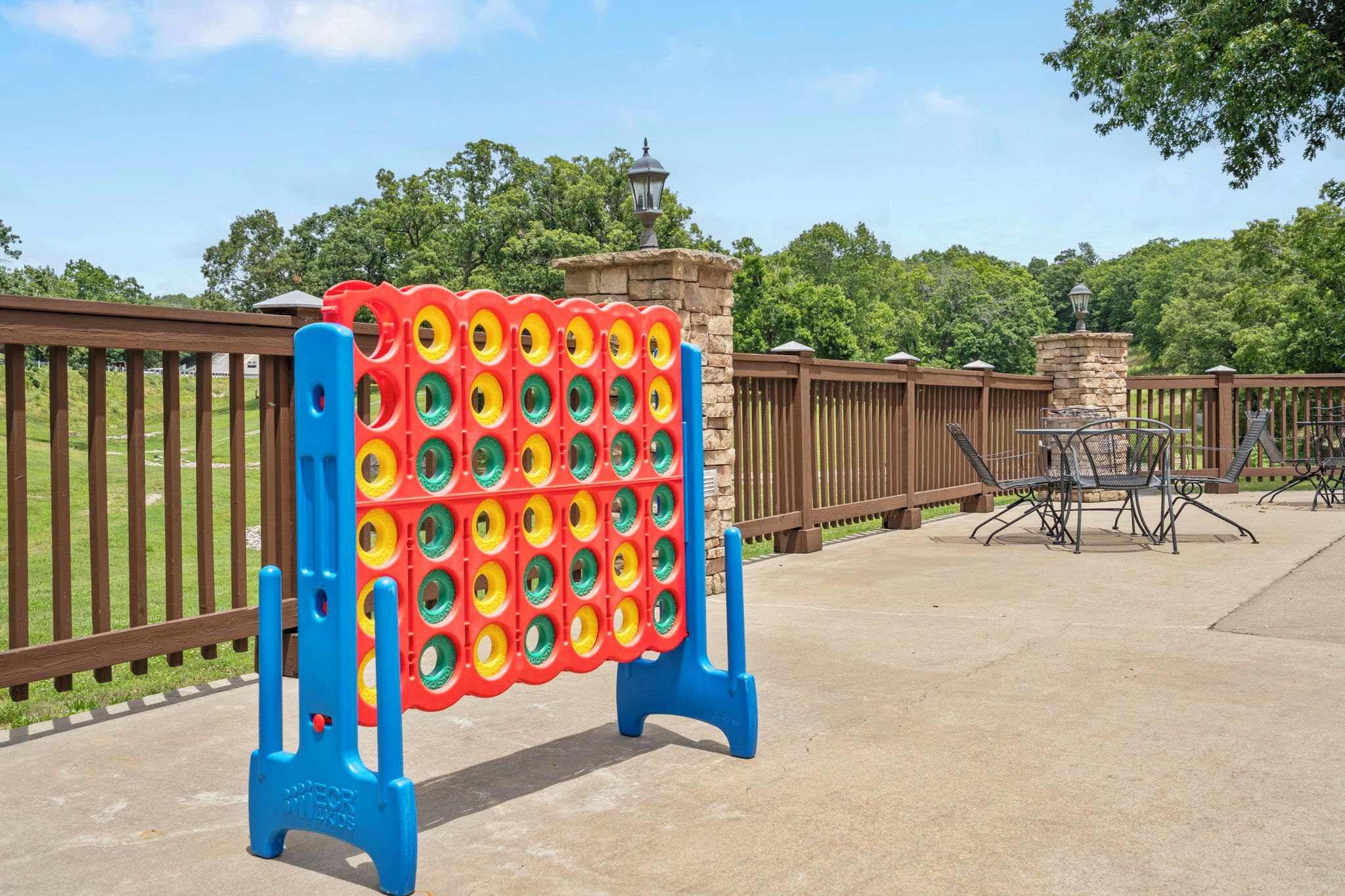 A pool area with a colorful inflatable pool structure and a seating area with metal chairs and tables.