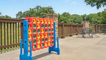 A pool area with a colorful inflatable pool structure and a seating area with metal chairs and tables.