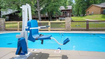A pool with a blue chair and a lifeguard stand.
