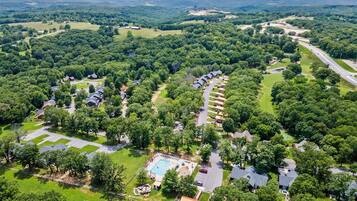An aerial view of a residential area with houses, a swimming pool, and a road.
