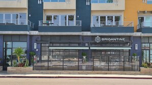 Un immeuble à plusieurs étages dont la devanture porte l’inscription « BRIGANTINE ».