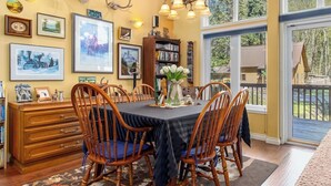 A dining area with a table set for four, surrounded by wooden chairs. - Moose Manor | Hot tub, Wifi, Fireplace, AC (Packwood)