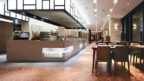 A modern cafe with a bar area, seating, and a visible restroom sign. - Traum Valley Hotel (Jeongseon)