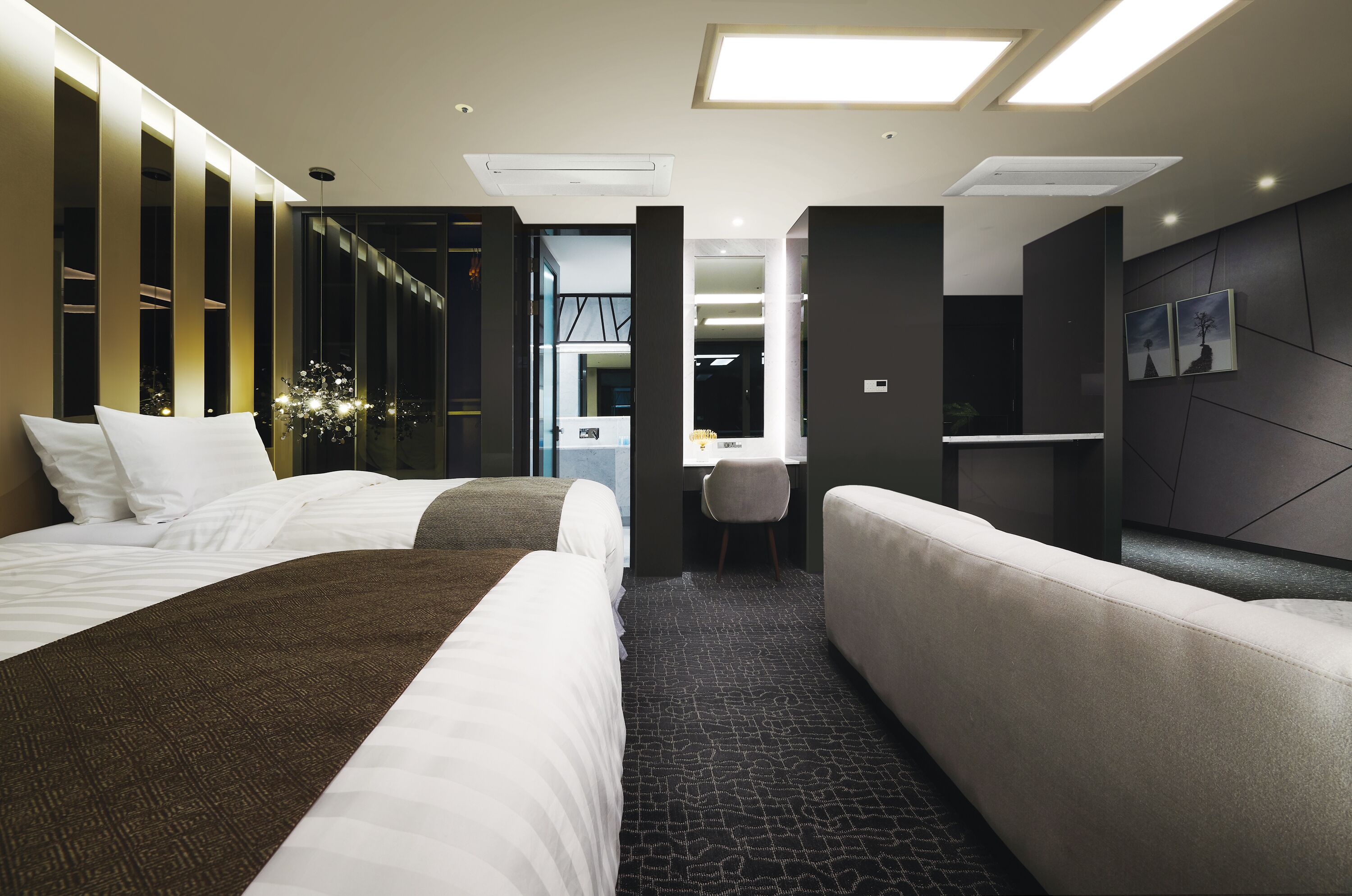 Una habitación de hotel moderna con dos camas, un escritorio y una zona de estar.