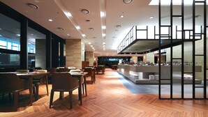 A modern interior with wooden flooring, a bar area, and seating arrangements. - Traum Valley Hotel (Jeongseon)