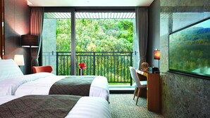 A hotel room with two beds, a desk, a chair, and a large window with a balcony. - Traum Valley Hotel (Jeongseon)