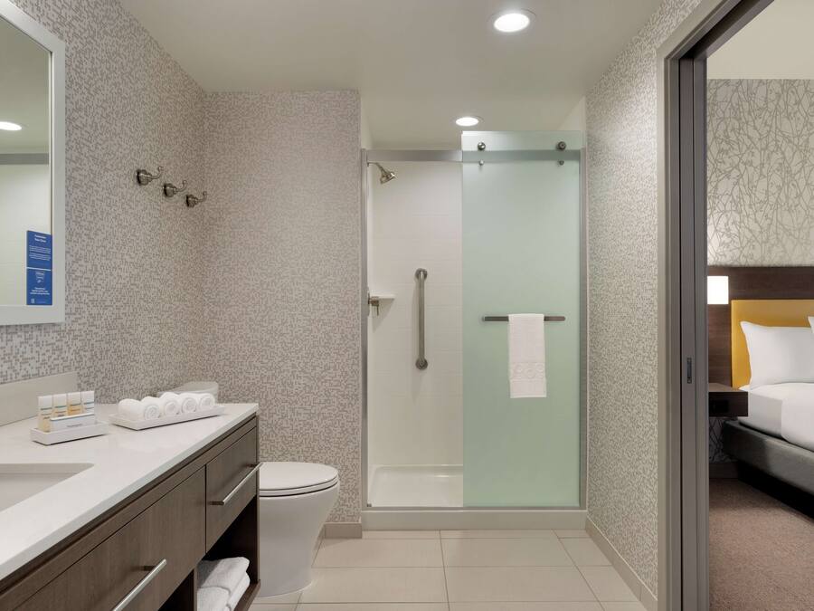 A modern bathroom with a shower, toilet, and sink.