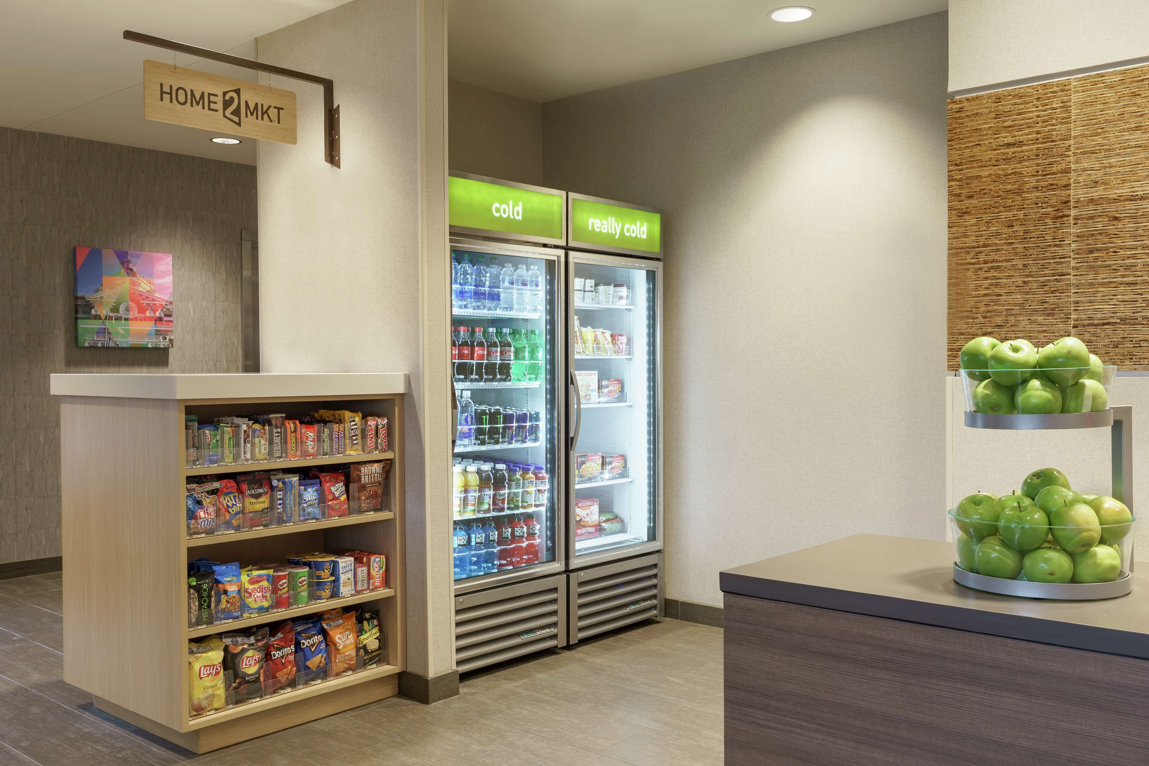 A snack bar with a variety of packaged foods and two beverage refrigerators labeled "cold" and "really cold".