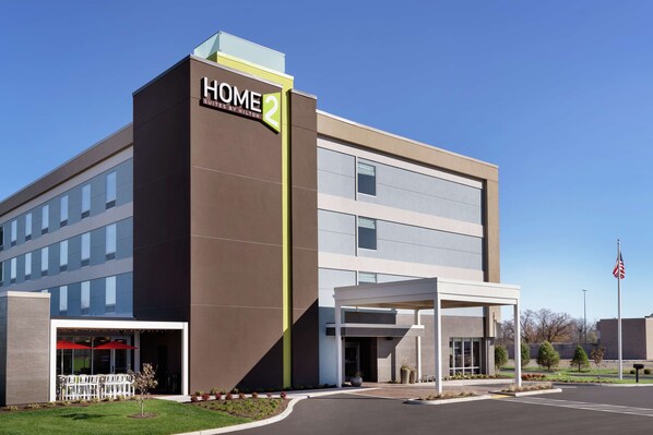 Un moderno edificio de hotel con un letrero que dice "HOME 2 SUITES BY HILTON".