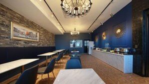 Restaurante com parede de tijolos, um candelabro e um espaço para buffet.