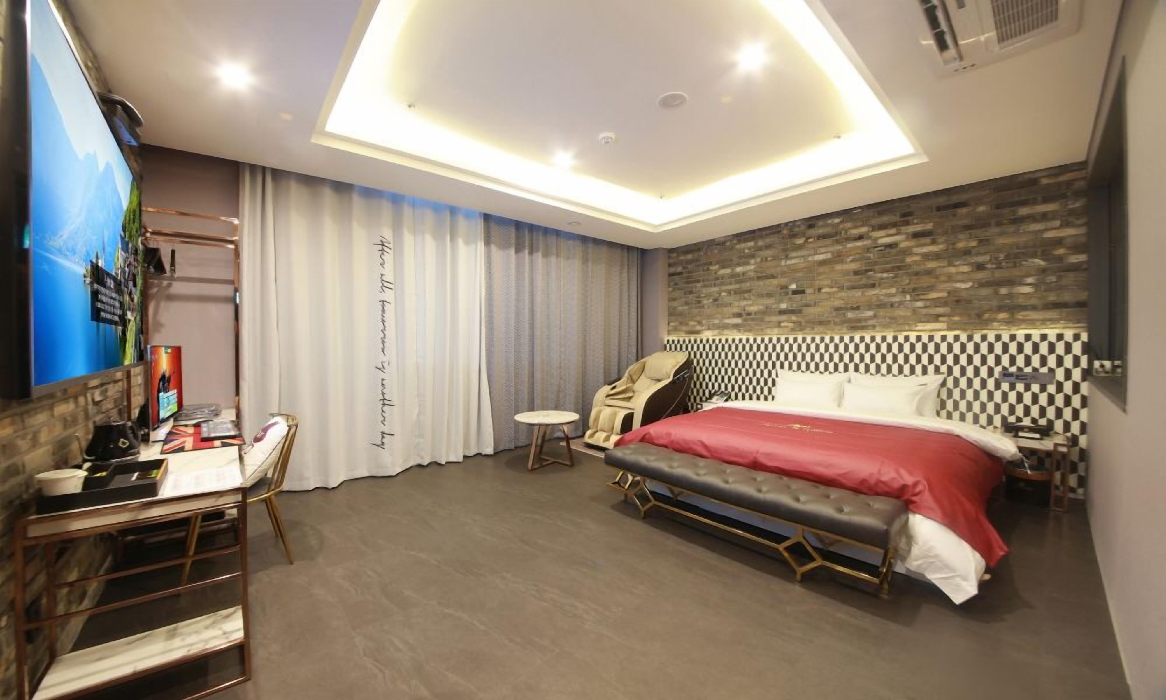 Une chambre à coucher moderne avec un grand lit, un bureau et une chaise.