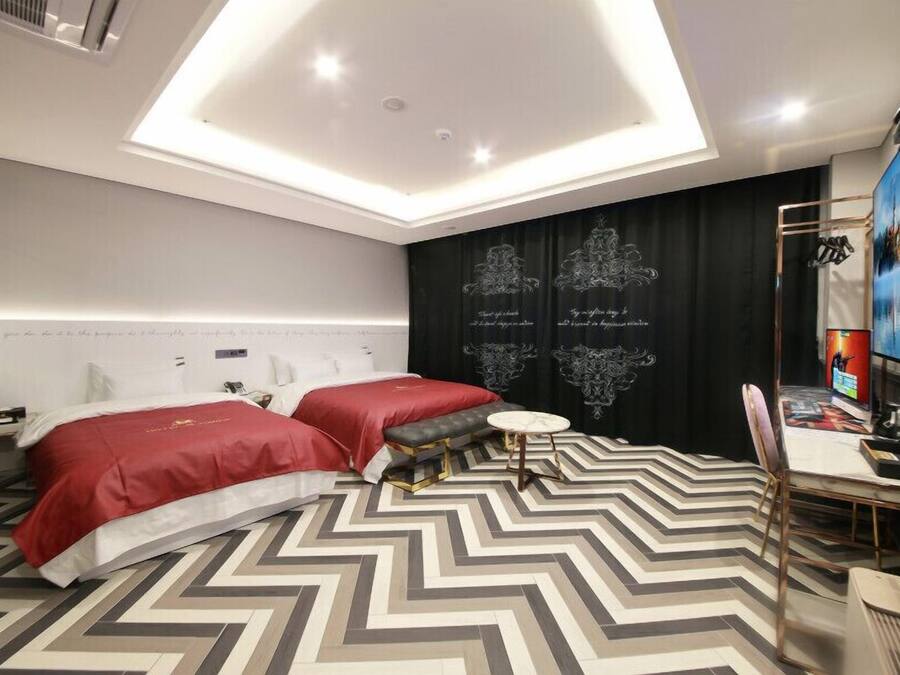 A modern hotel room with a large bed, a small round table, and a TV.